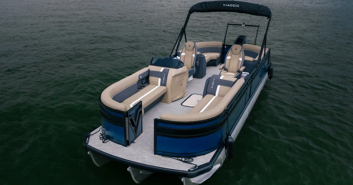Aerial view of a Viaggio Lago X tritoon with tan and navy lounge seating and a black bimini top on open water